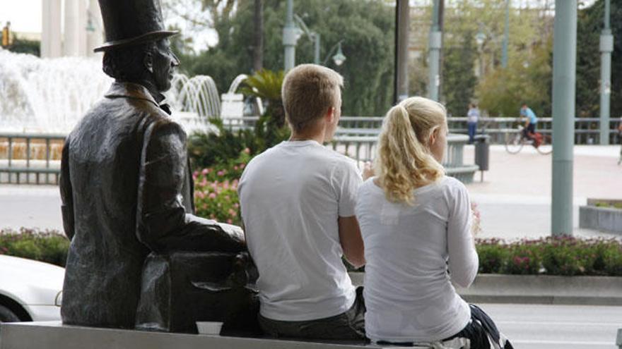 Turistas extranjeros sentados en la estatua de Andersen.
