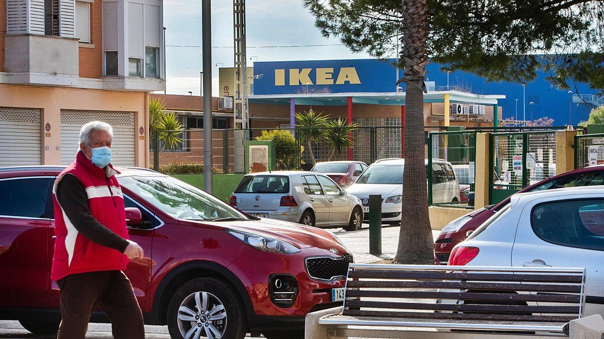 Un vecino de Alfafar pasea por la zona urbana desde la que se ve la tienda de Ikea, al fondo. | LEVANTE-EMV