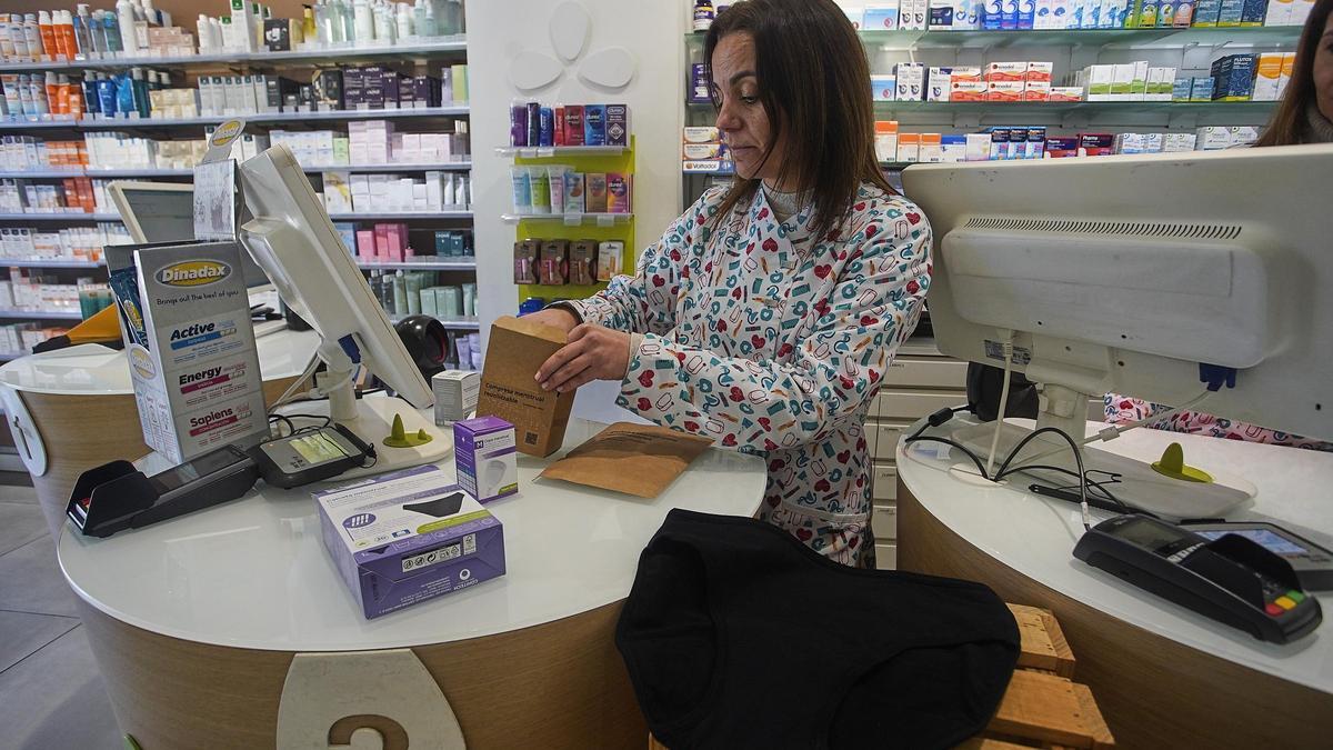 Una farmacèutica de Girona mostra els productes menstruals.