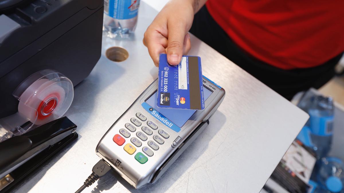 Una persona paga con una tarjeta de crédito en una tienda.