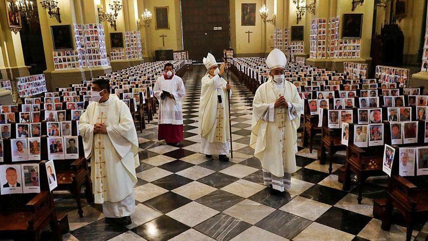 Miles de fotografías de fallecidos por el Covid-19 en Perú, durante la misa oficiada en su homenaje en la Catedral de Lima.