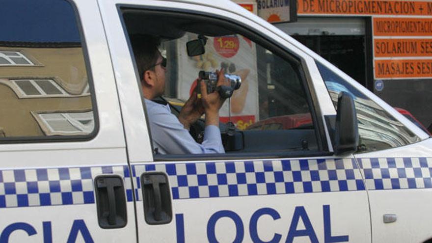 Un policía se dispone a grabar con la cámara de vídeo desde un vehículo policial.