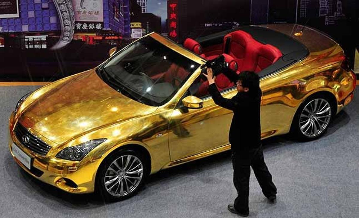 Un home filma un Infiniti G37 recobert d’or en una joieria a Nanjing (Xina), realitzat per cinc artesans durant quatre mesos, com un acte de promoció de la botiga.