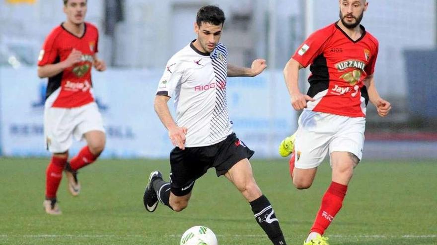 Annunziata conduce el balón perseguido por dos jugadores del Tudelano.