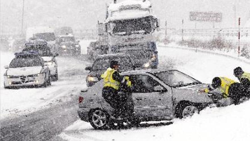 Agents de la Guàrdia civil retiren un vehicle accidentat per culpa de la neu, ahir a Cantàbria.