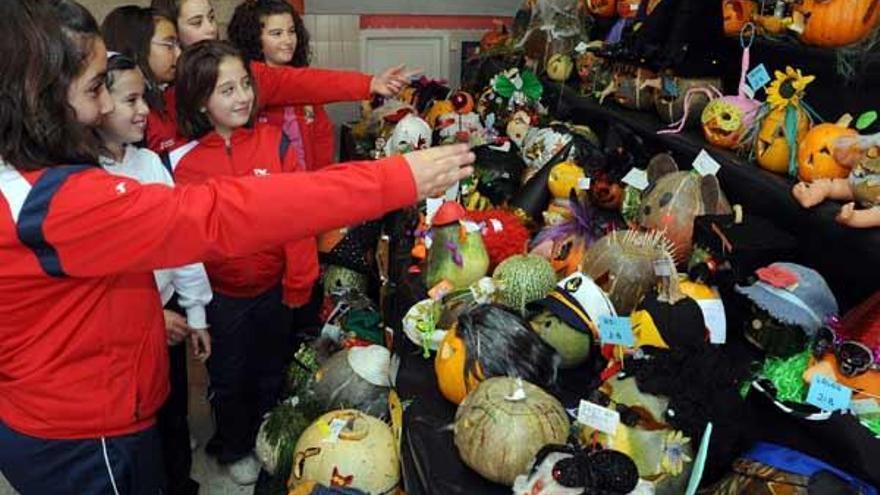 Alumnos de A Illa observan ayer la exposición de calabazas decoradas.  // Iñaki Abella