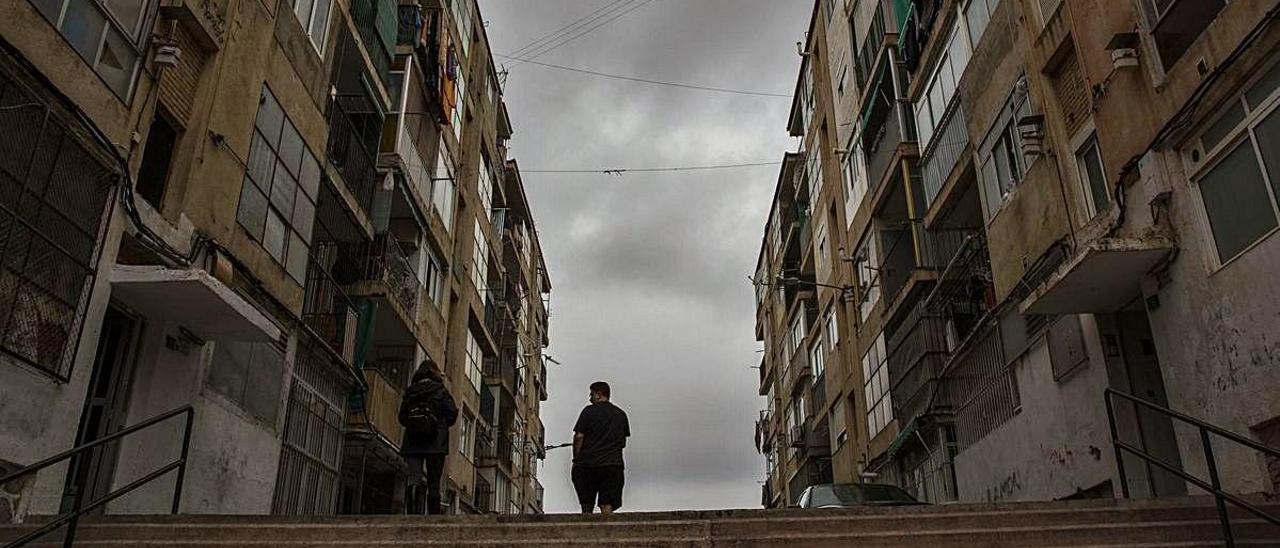 Una persona ubicada entre dos bloques de edificios en un céntrico barrio de Alicante con viviendas de alquiler social.