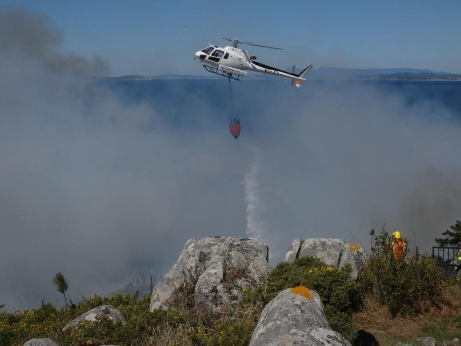 Las exhaustas labores de extinción del incendio de Cangas. // S. Álvarez