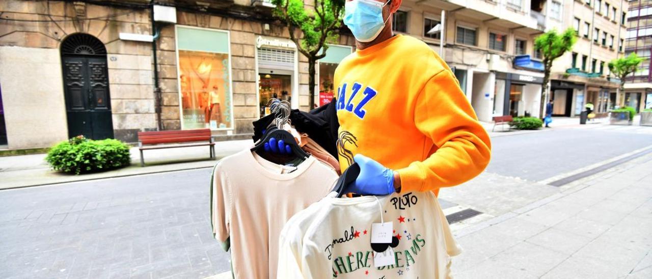 Un empleado porta prendas para una tienda. // G. Santos