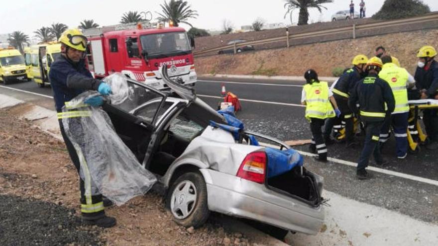 Los bomberos junto al vehículo accidentado el sábado en Arrecife.