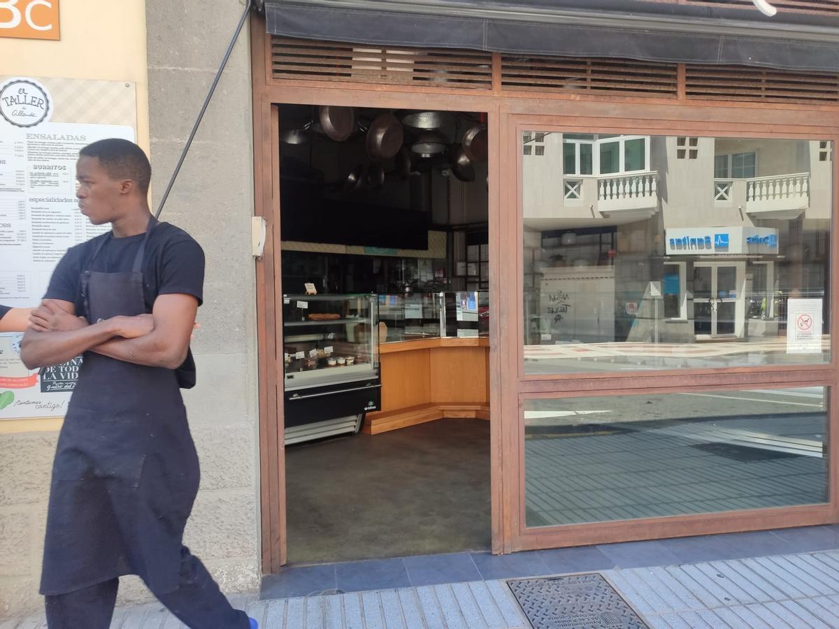 Un empleado esperando fuera de su local a que vuelva la luz.
