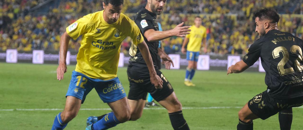 Enzo Loiodice, presionado por Aitor Sanz y Mellot –derecha–, en una acción de la primera parte del derbi entre la UD Las Palmas y el CD Tenerife. | | JOSÉ CARLOS GUERRA