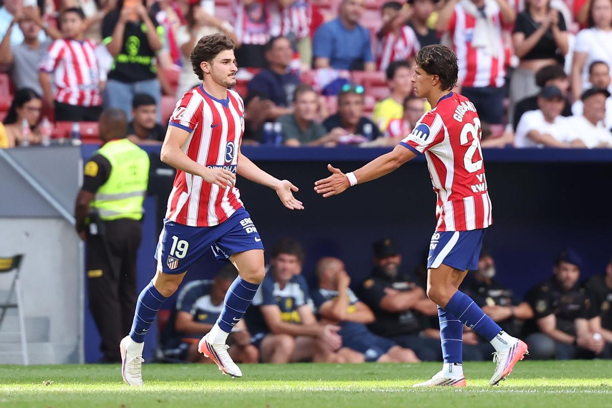 El delantero del Atlético de Madrid Guiuliano Simeone (d) saluda a Julián Álvarez al entrar en el terreno de juego, durante el partido de LaLiga de fútbol que Atlético de Madrid y Villarreal CF disputan este domingo en el estadio Metropolitano.
