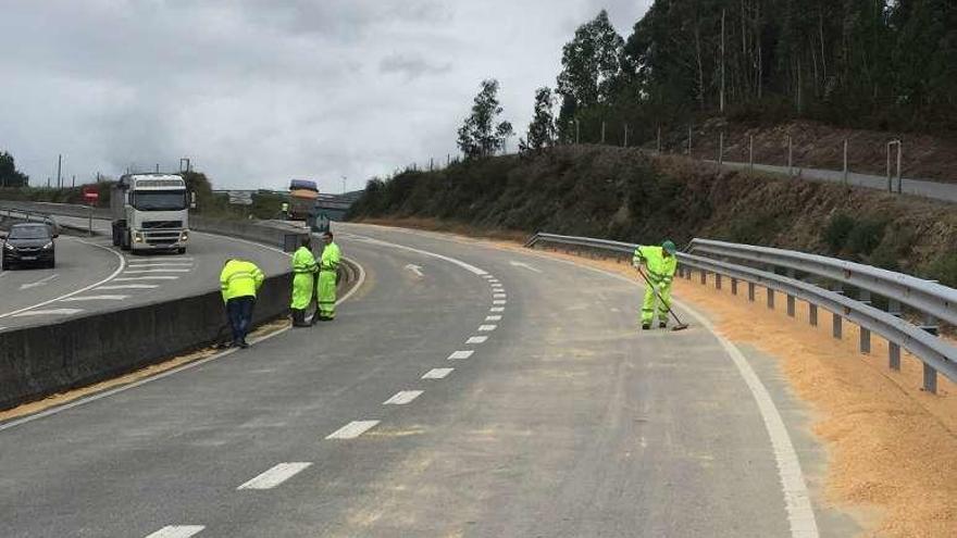 Tareas de limpieza del grano derramado en la carretera. // Faro