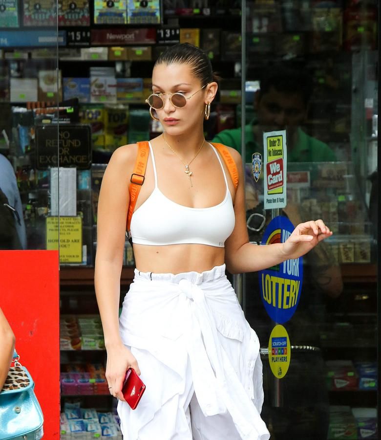 Bella Hadid con pantalones anchos, camisa blanca y top