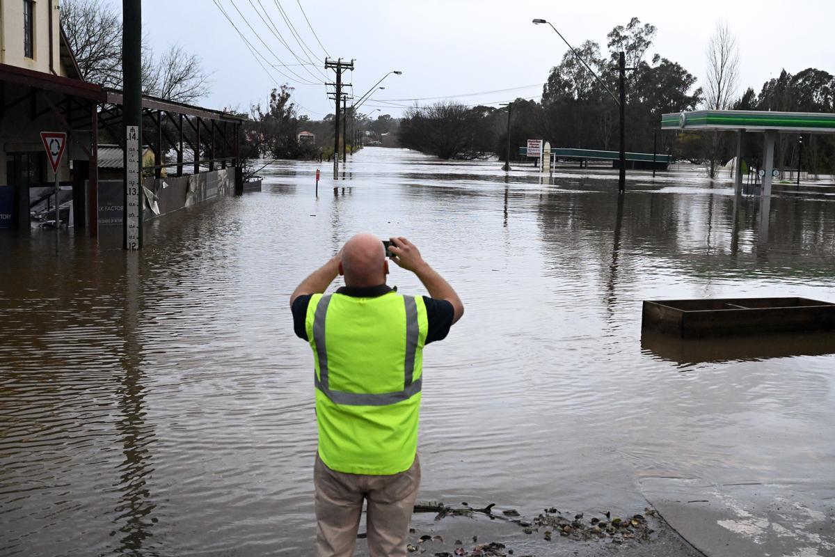  Un lugareño toma una foto de una carretera inundada por las inundaciones en Camden, en el suroeste de Sydney, Australia, el 03 de julio de 2022. Lluvias torrenciales y vientos dañinos azotaron el estado de Nueva Gales del Sur obligando a la evacuación de miles de residentes. El ministro de servicios de emergencia de Nueva Gales del Sur, Steph Cooke, advirtió a los ciudadanos que las inundaciones podrían ser más peligrosas que las del año pasado. (Inundaciones, Estados Unidos) EFE/EPA/MICK TSIKAS FUERA AUSTRALIA Y NUEVA ZELANDA