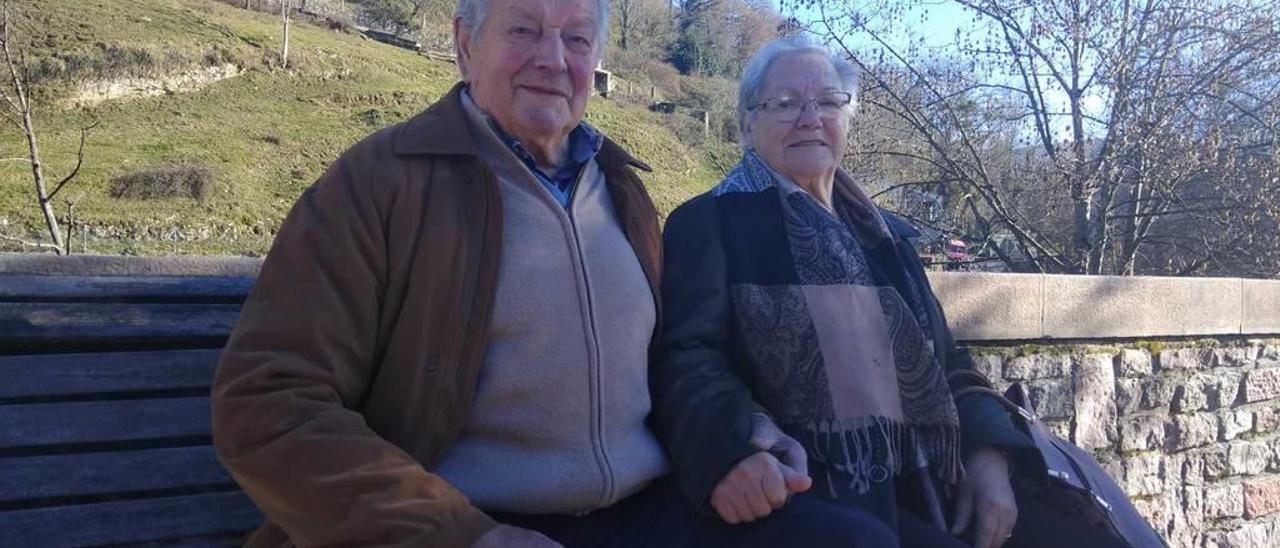 Antonio González y Neli Fernández, sentados junto al río, en Infiesto.