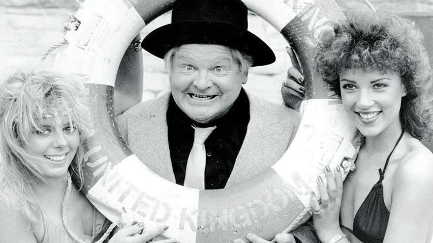 El comediante británico Benny Hill junto a dos modelos en bikini, en septiembre de 1983.