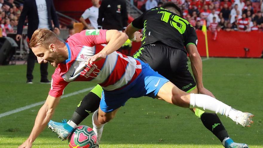 Roberto Soldado, con los colores del Granada, disputa el balón con el bético Álex Moreno.