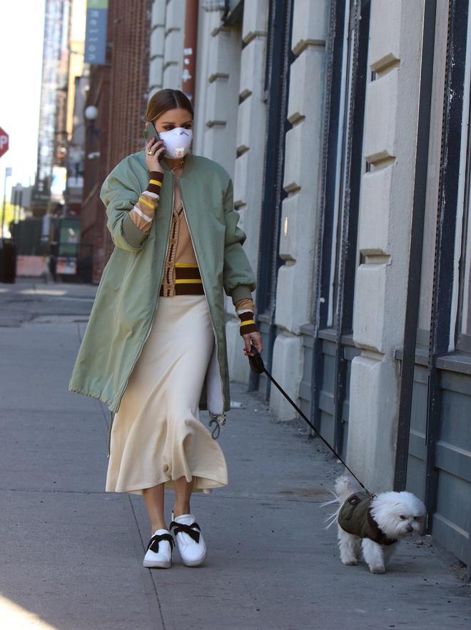 Olivia Palermo con falda midi, chaqueta larga y zapatillas