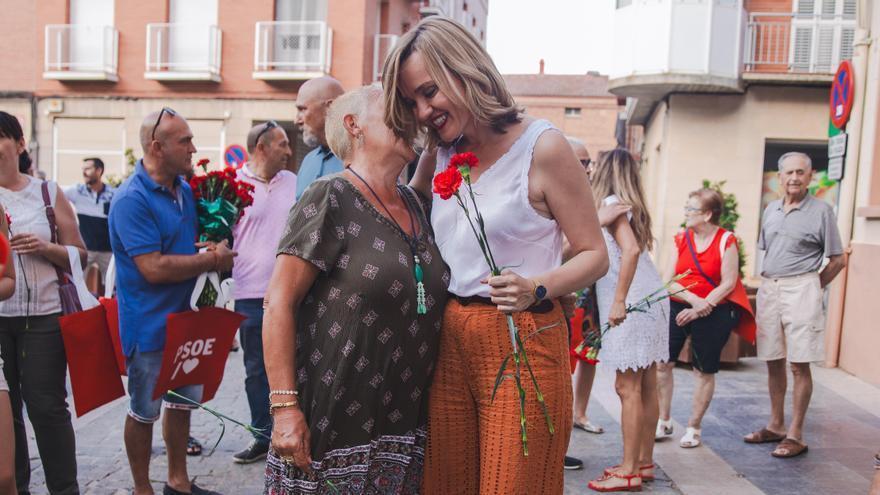 Pilar Alegría abraza a una mujer en Cariñena, donde regaló claveles.