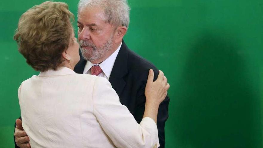 Lula y Rousseff (de espaldas) se abrazan durante la ceremonia de nombramiento del primero como ministro. // Reuters
