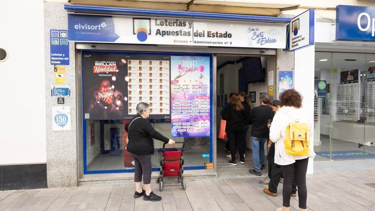 Unas personas hacen cola en una administración de lotería