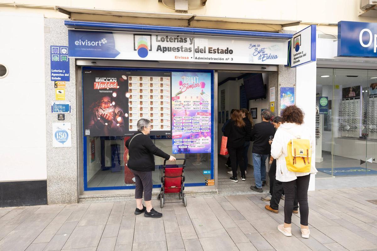 Unas personas hacen cola en una administración de lotería