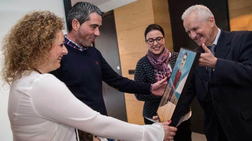 Pruneda recibe la caricatura de Pablo García de manos de Melchor Fernández en presencia de Ángeles Rivero y ante la mirada de su mujer, Mariola.