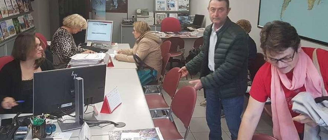 Pensionistas contratando viajes del Imserso en la agencia Halcón Viajes de García Barbón. // A. Blanco