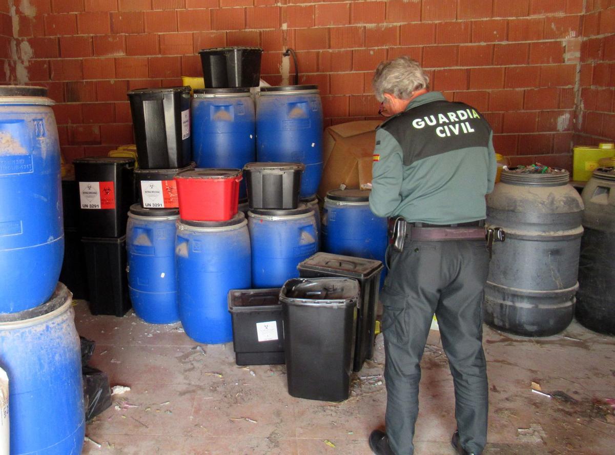 Un agente, junto a bidones de residuos peligrosos hallados en Lorquí.