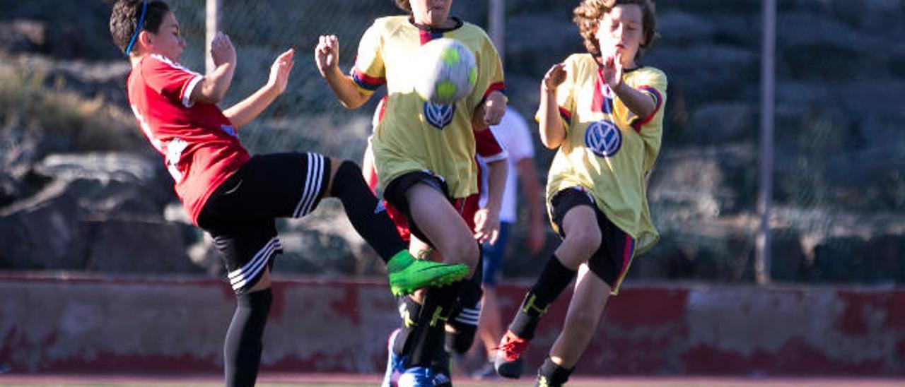 Óscar intenta despejar el balón junto a Joaquín y Ale.