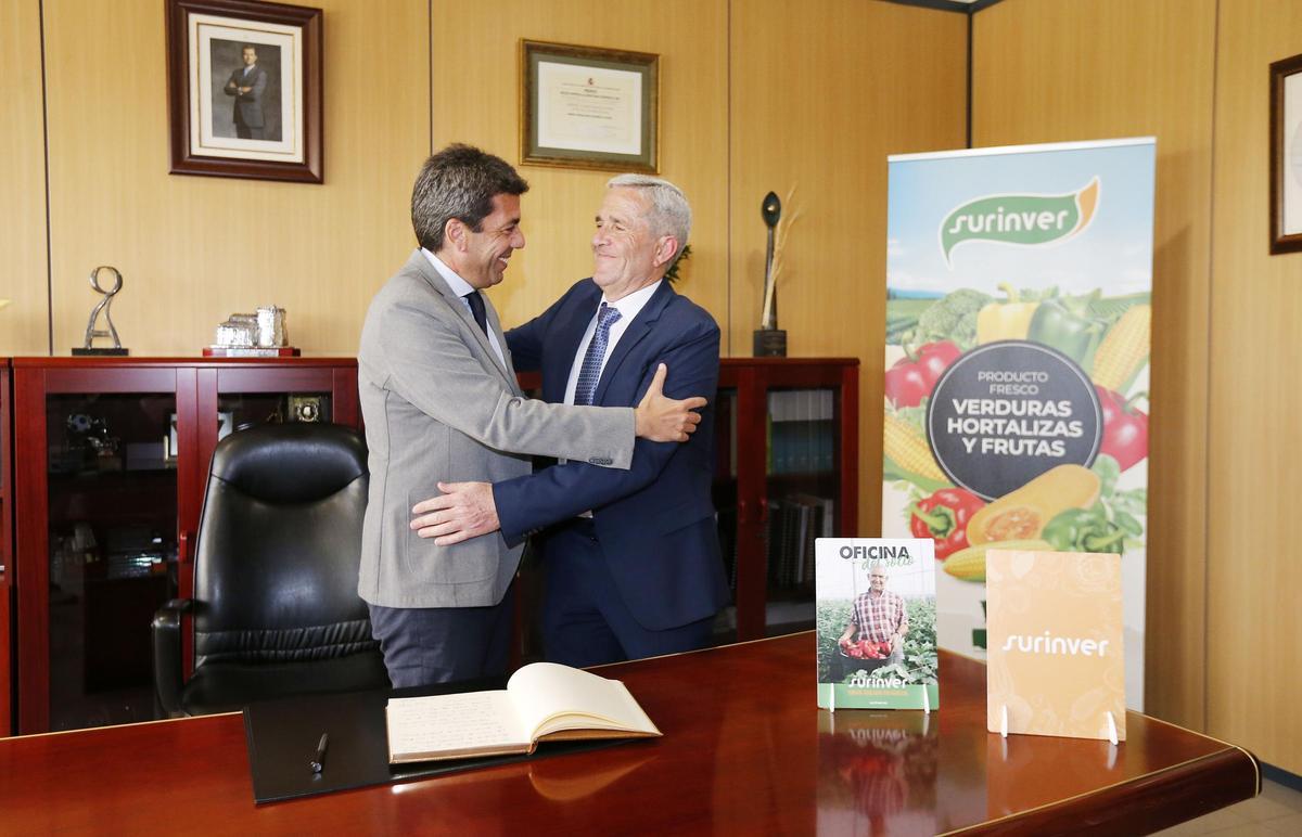 Carlos Mazón abraza al presidente de Surinver, José María Pérez Sánchez, tras firmar en el libro de honor de la cooperativa de Pilar de la Horadada
