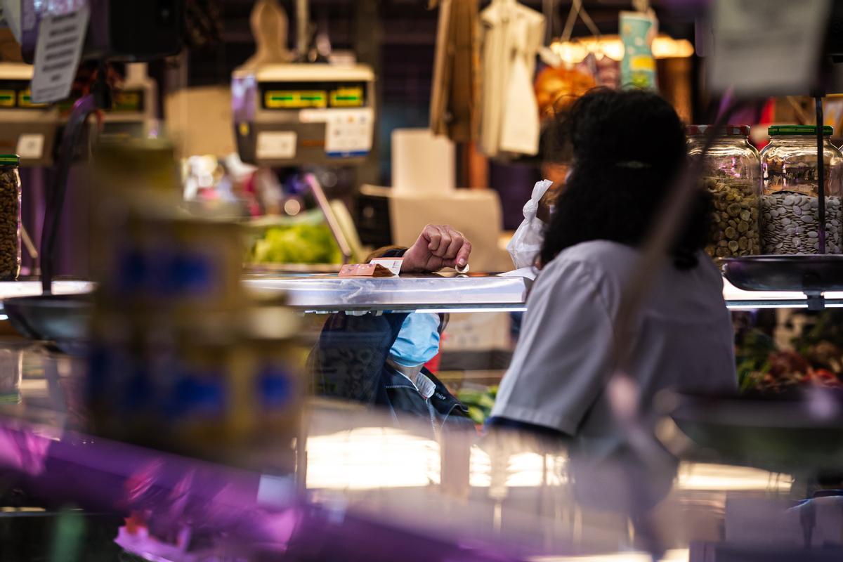 Una clienta paga su compra en el Mercado de Maravillas.