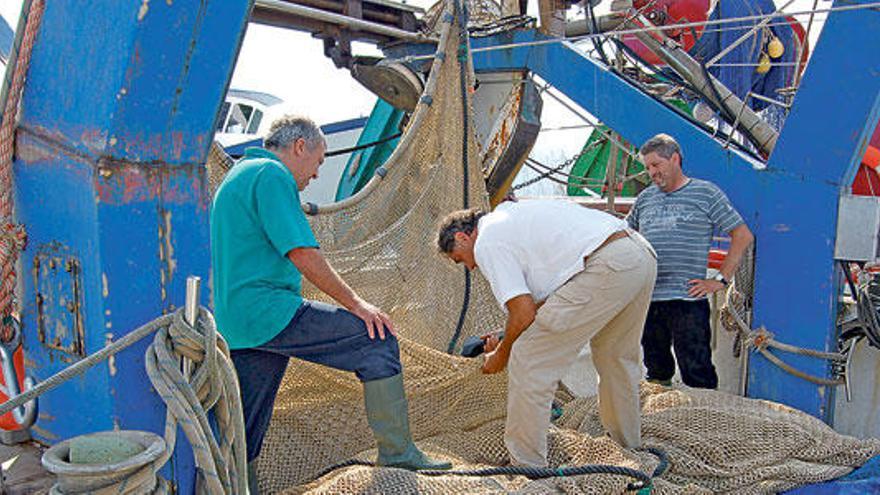 Un inspector de pesca examina la dimensión del paso de malla del ´bou´, o red de arrastre, que usa el Punta del Vent en Alcúdia.