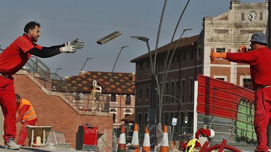Dos trabajadores de la construcción urbanizan una calle de Bilbao durante la jornada de ayer.