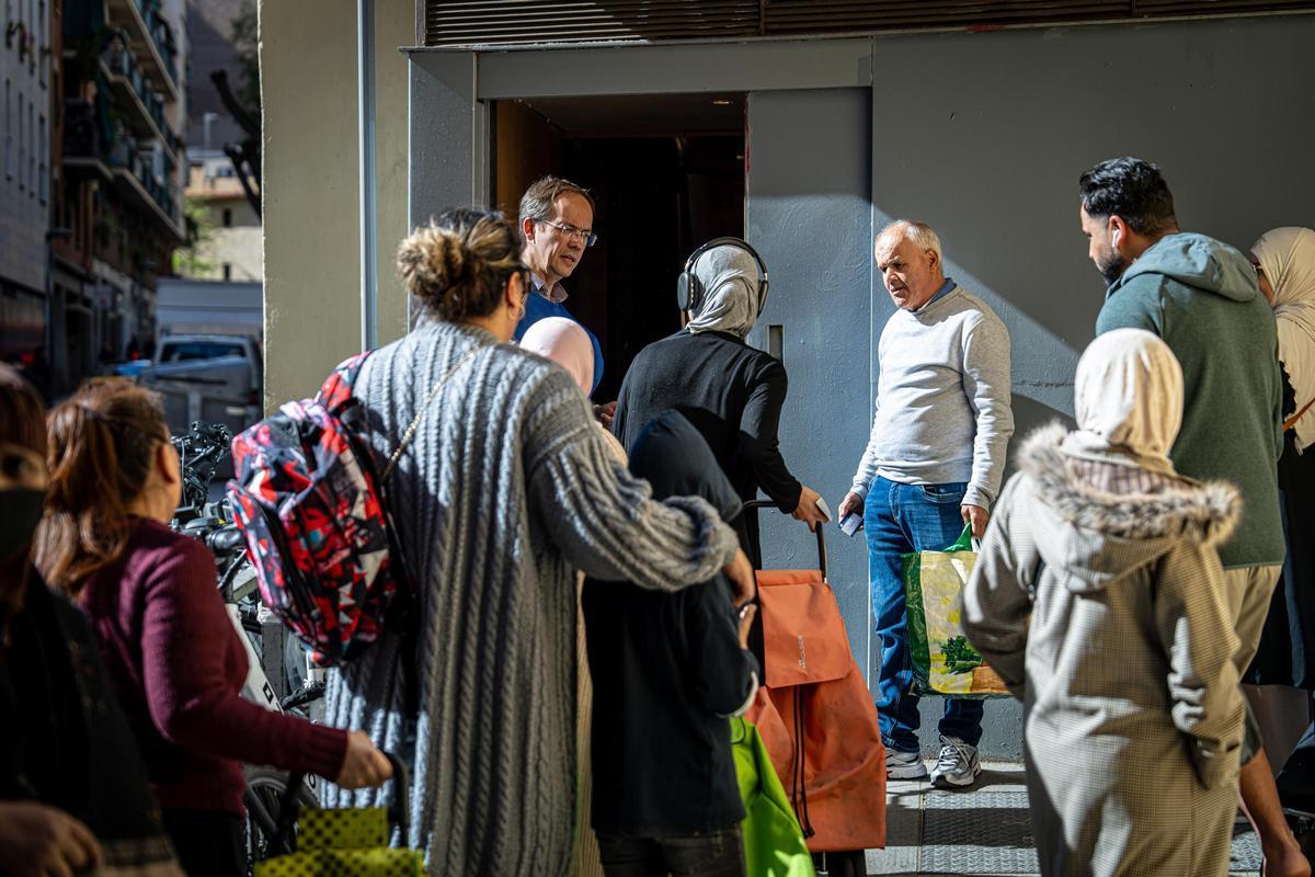 La Comunidad de San Egidio distribuye comida entre personas sin recursos, que hacen fila para recibirla.