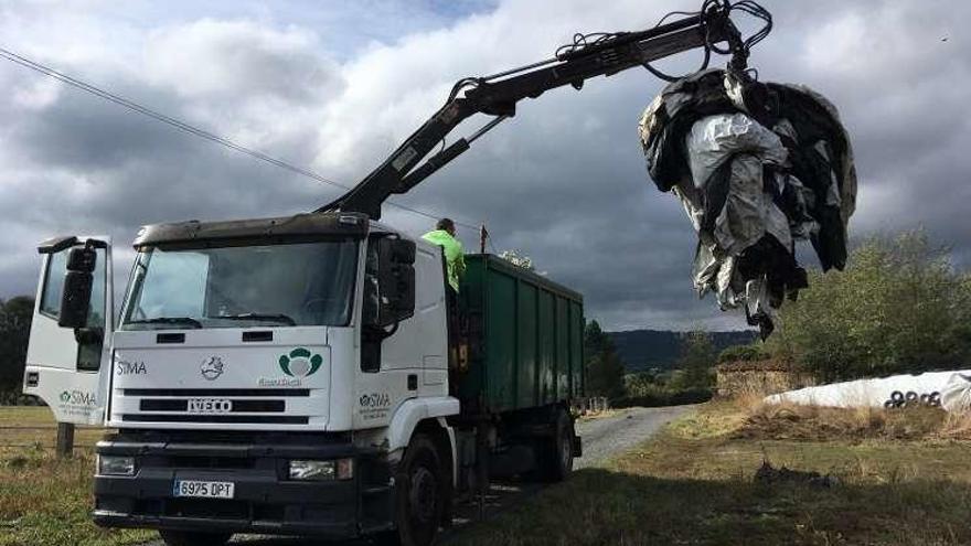 La empresa SIMA y operarios del Concello se encargan de retirar plásticos agrícolas usados ayer, en una aldea de Silleda.