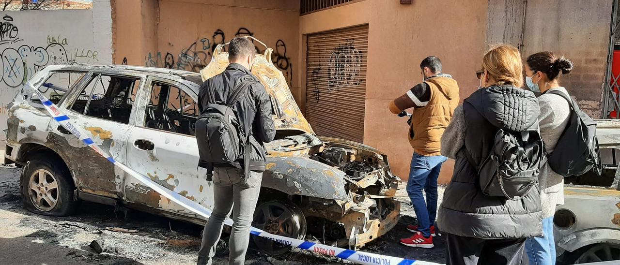 Policías nacionales examinan los coches calcinados en Vila-real.