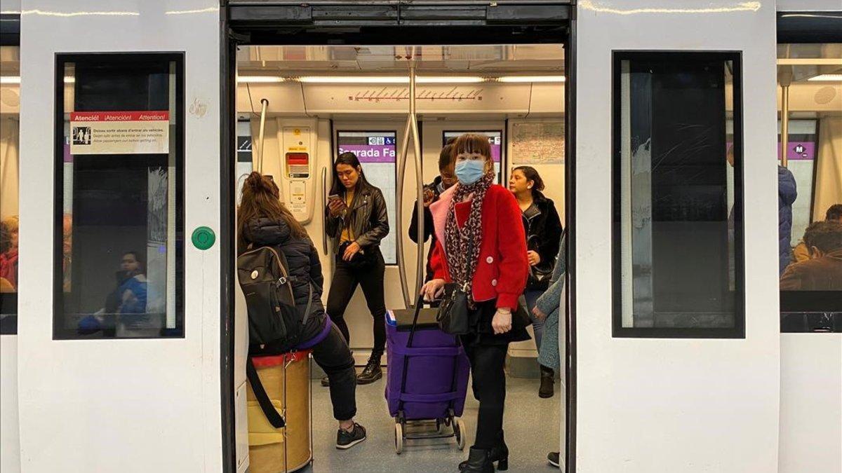 Una mujer con mascarilla para protegerse del coronavirus, en el metro de Barcelona