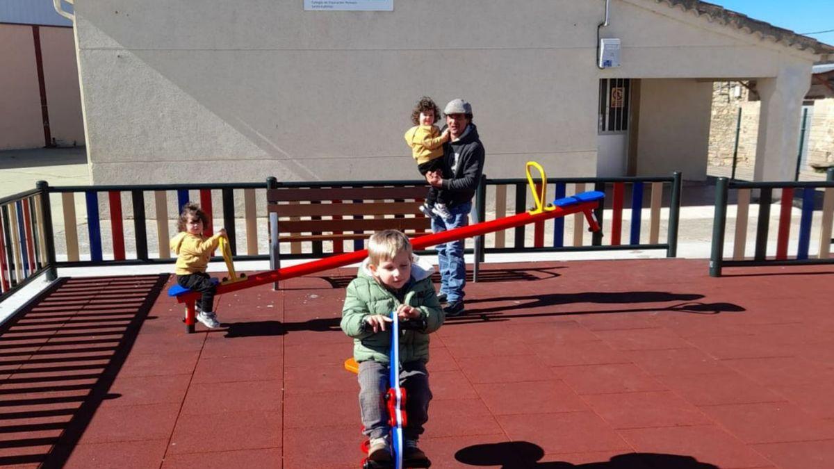 Tres pequeños que empezarán en la escuela el próximo curso en Pereruela, jugando en el parque.