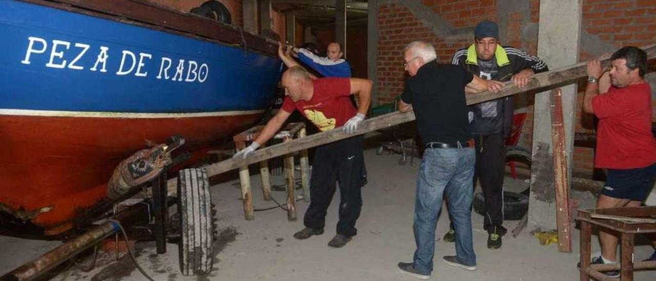 Integrantes de la Escola de Navegación Tradicional guardan la dorna de tope &quot;Peza de Rabo&quot;. // Noé Parga