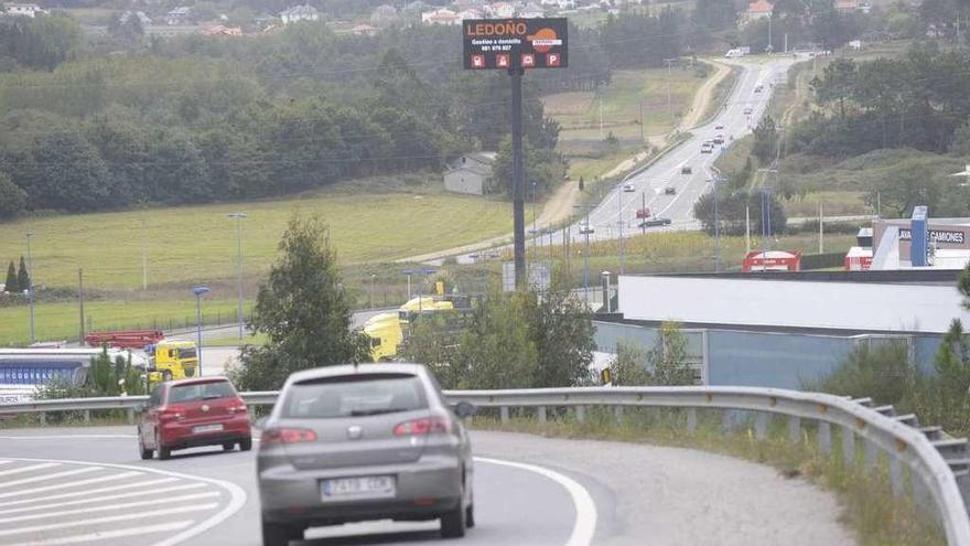 Varios coches circulan por la carretera de Ledoño a Cerceda.