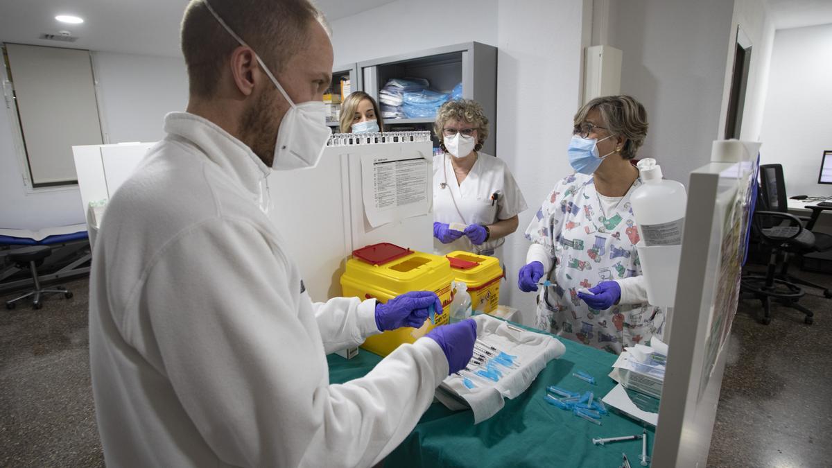Personal de un centro de salud se prepara para vacunar a pacientes.