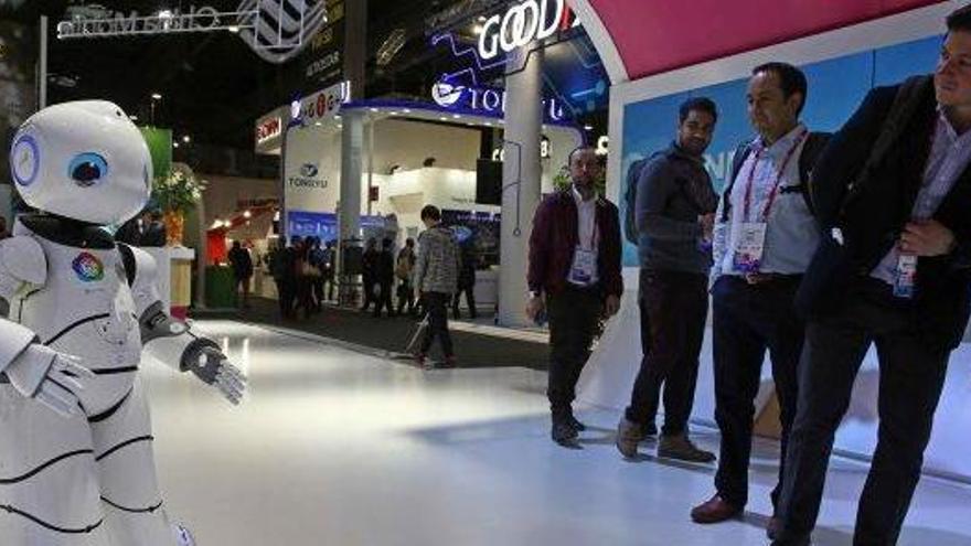 Visitants observen un robot en un estand del congrés de telefonia mòbil de Barcelona