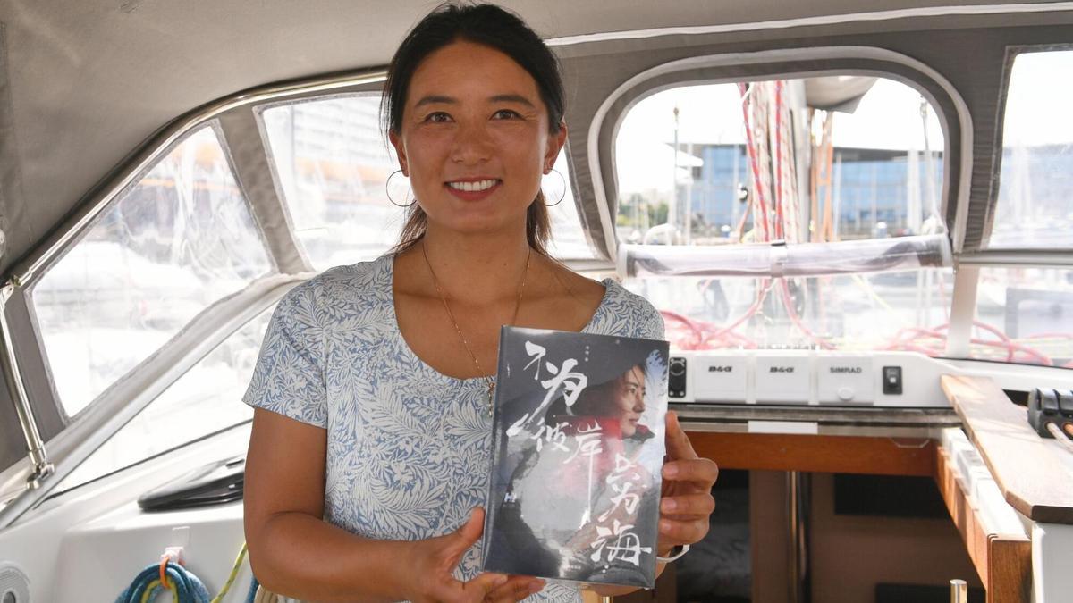La pionera china, Vicky Song, posa con su libro narrando el viaje alrededor del mundo en vela.