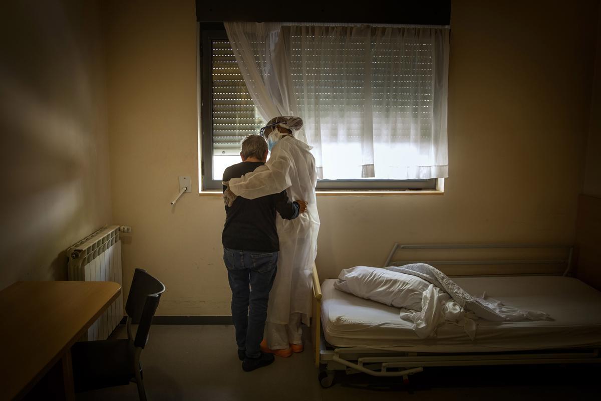 Una anciana y una trabajadora se abrazan en la habitación en la que la primera permanece confinada, en una residencia de la provincia de Barcelona, España, 29 de abril, 2020
