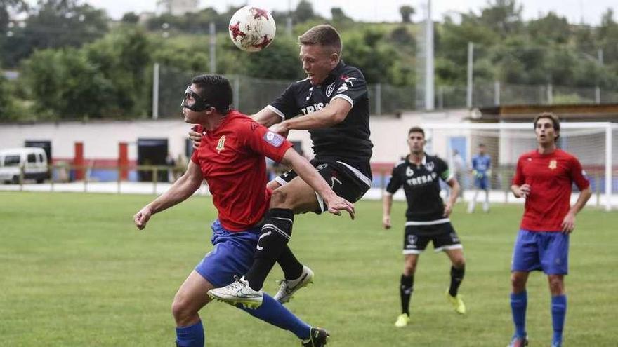 El local Aitor Suárez disputa un balón de cabeza con el visitante Miguel.