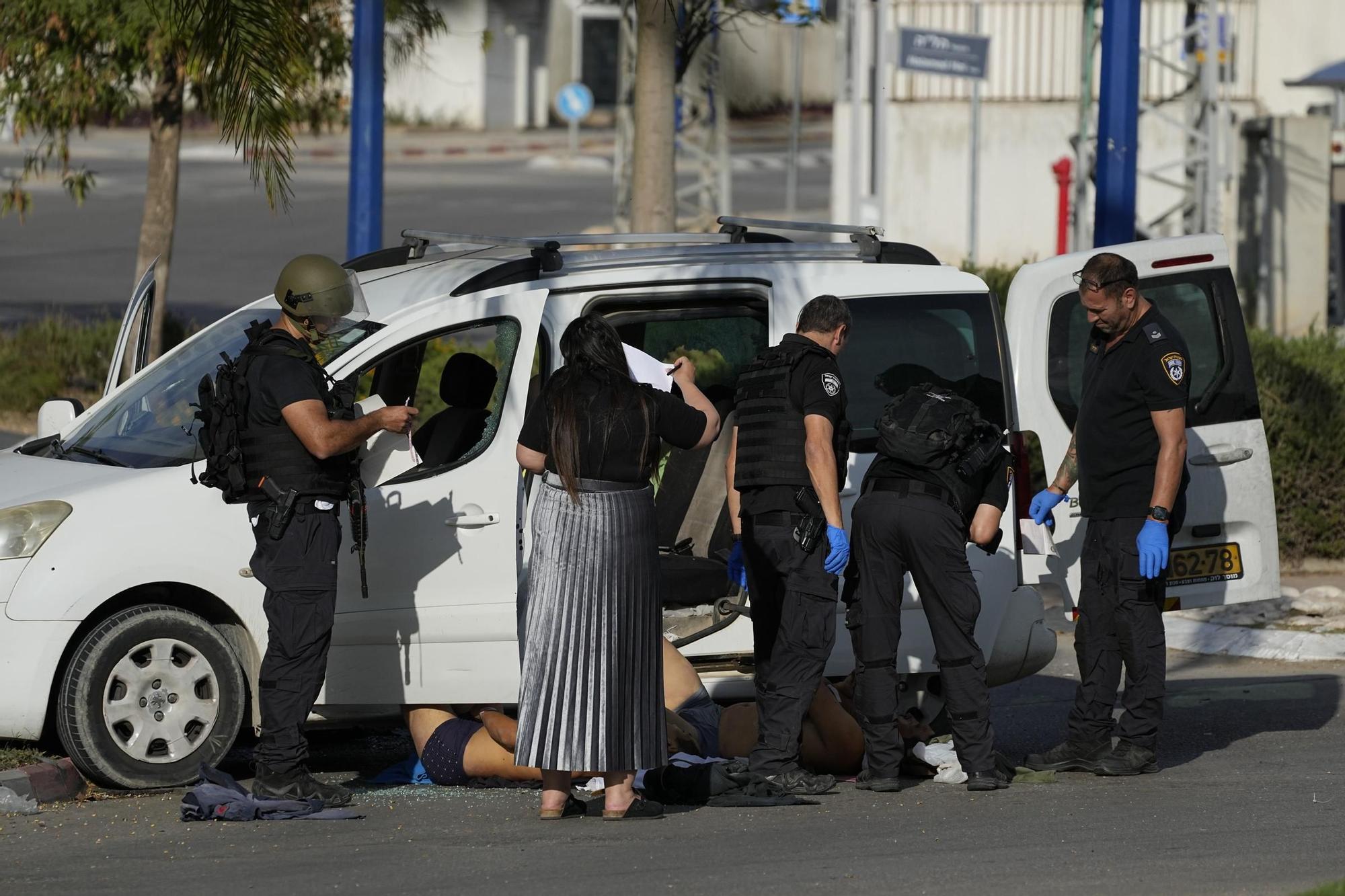 Agentes de la policía de Israel junto a víctimas muertas a mano de militantes palestinos en Sderot, Israel.