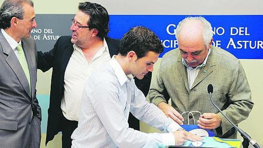 Mata firma un autógrafo a Fernández Porrón (director general de Deportes), con Óscar Celada a la izquierda de la foto.